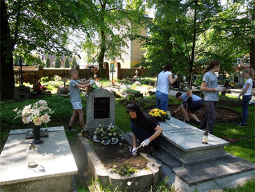 Groupe d'élèves et d'adultes en train de restaurer un cimetière