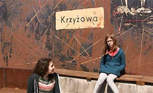 Krzyżowa en Pologne: deux filles assises devant le panneau de l'exposition