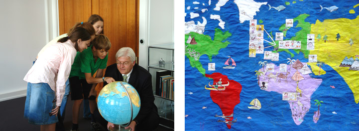 Die Kinderreporter schauen eine Weltkarte mit Außenminister Steinmeier an